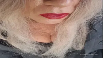 Mature shemale with strong red lipstick teases while smoking seductively